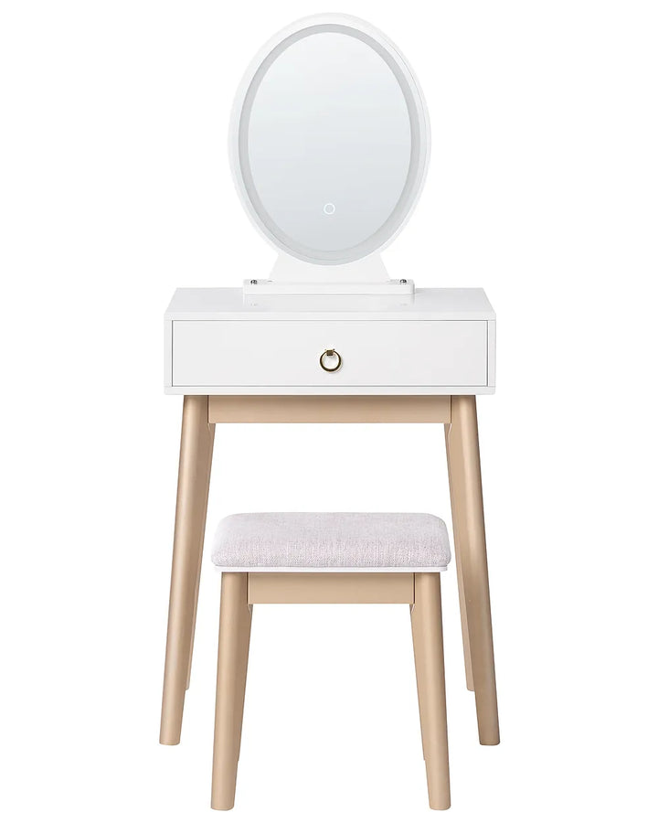 White vanity table with an oval mirror, a single drawer with a gold pull handle, and a matching stool with a light pink cushion, set against a plain white background.