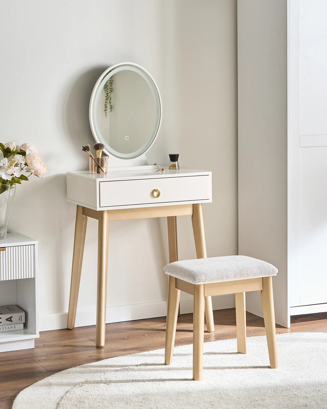 Dresser with round mirror and stool in a room setting