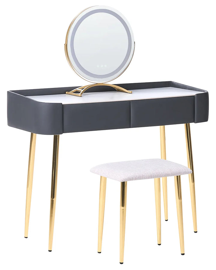 A modern vanity table set with a rectangular desk, a round LED-backlit mirror on a gold stand, and a matching stool with a light gray upholstered seat and gold legs, shown on a white background.