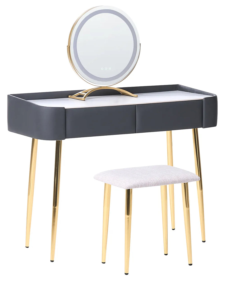 A modern vanity table set with a rectangular desk, a round LED-backlit mirror on a gold stand, and a matching stool with a light gray upholstered seat and gold legs, shown on a white background.