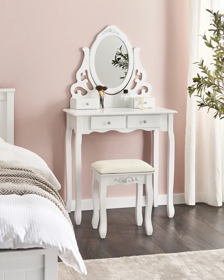 White vanity table with mirror and stool in a bedroom setting