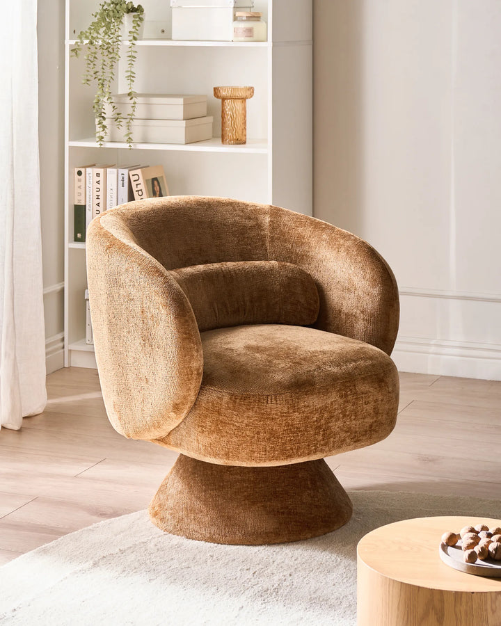 Brown textured armchair in a room with a bookshelf and small table.