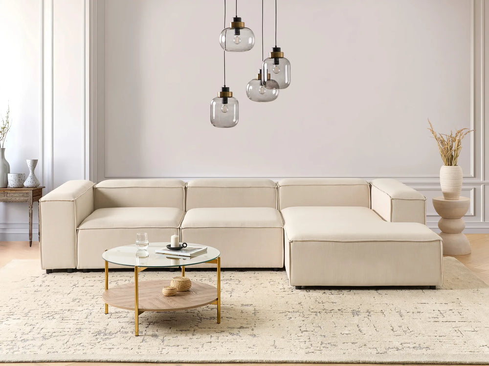 Beige sectional sofa in a modern living room with a coffee table and decorative items.