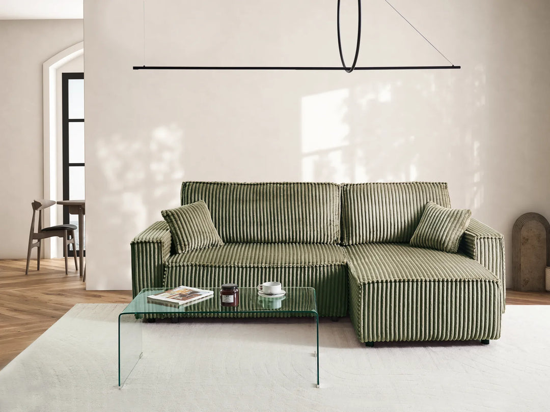 Green striped sofa in a modern living room with a glass coffee table.