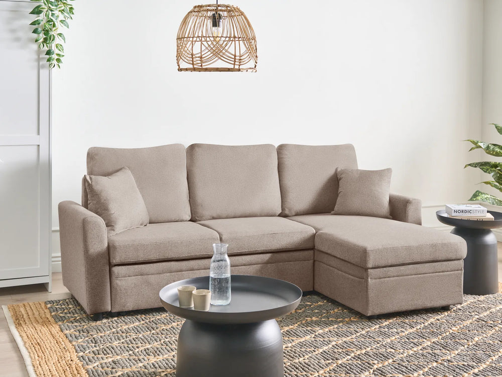 Beige sectional sofa in a living room setting with a coffee table and decorative items.
