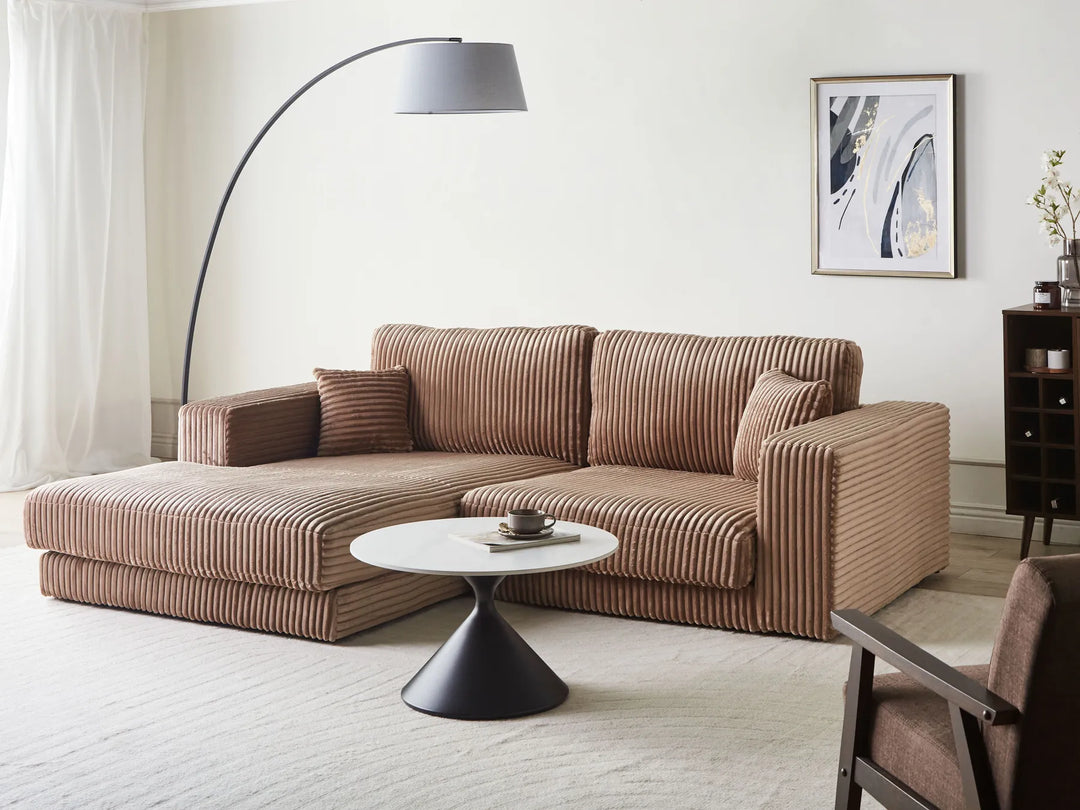 Brown sectional sofa in a living room with a floor lamp and coffee table.