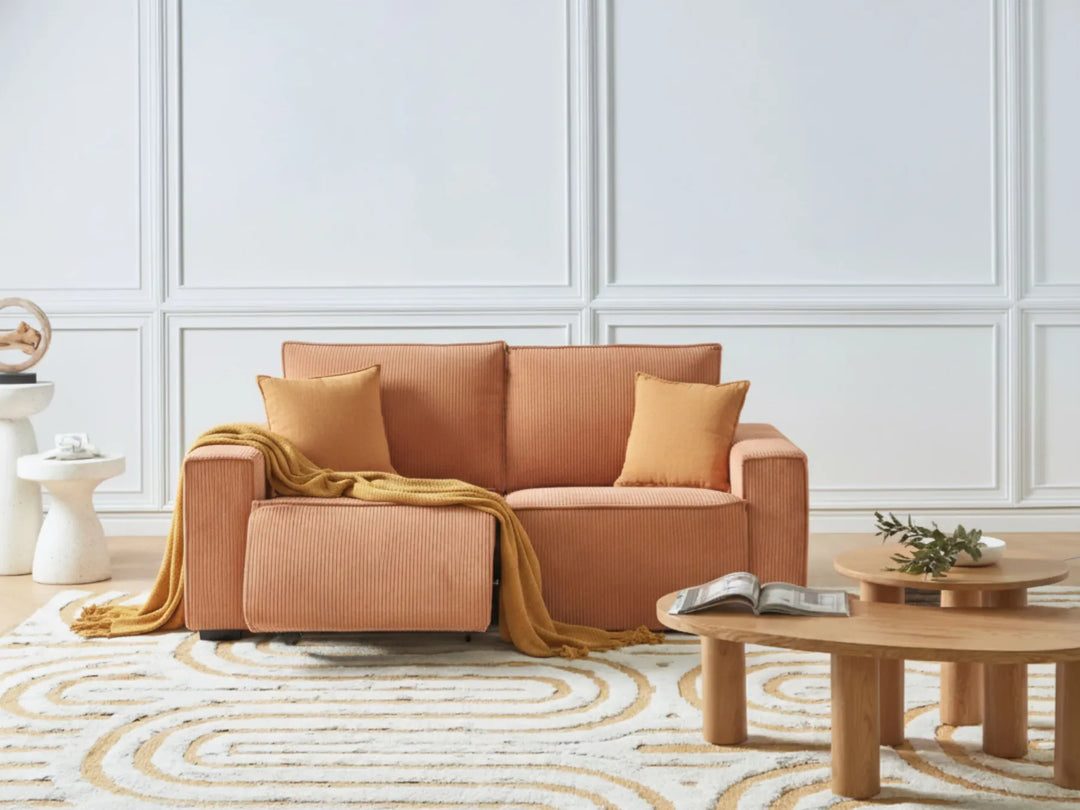Brown sofa with cushions and a blanket in a living room setting.