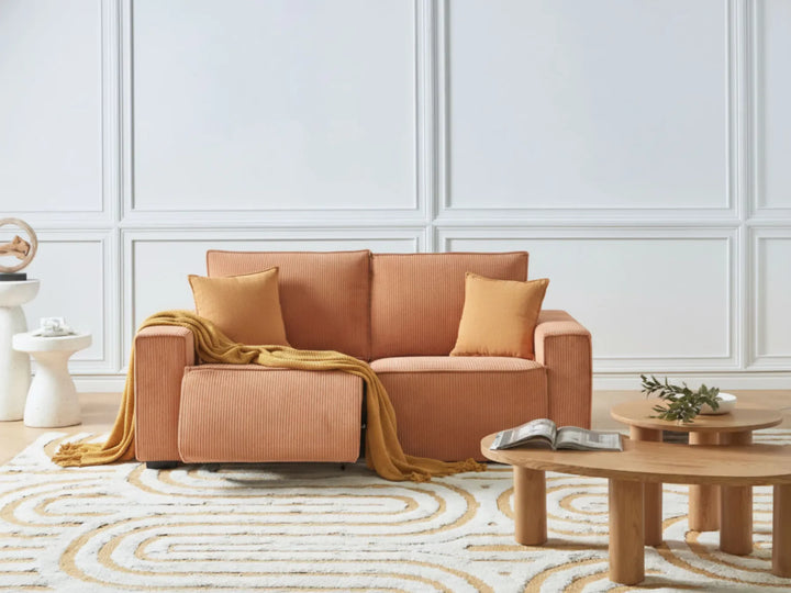 Brown sofa with cushions and a blanket in a living room setting.