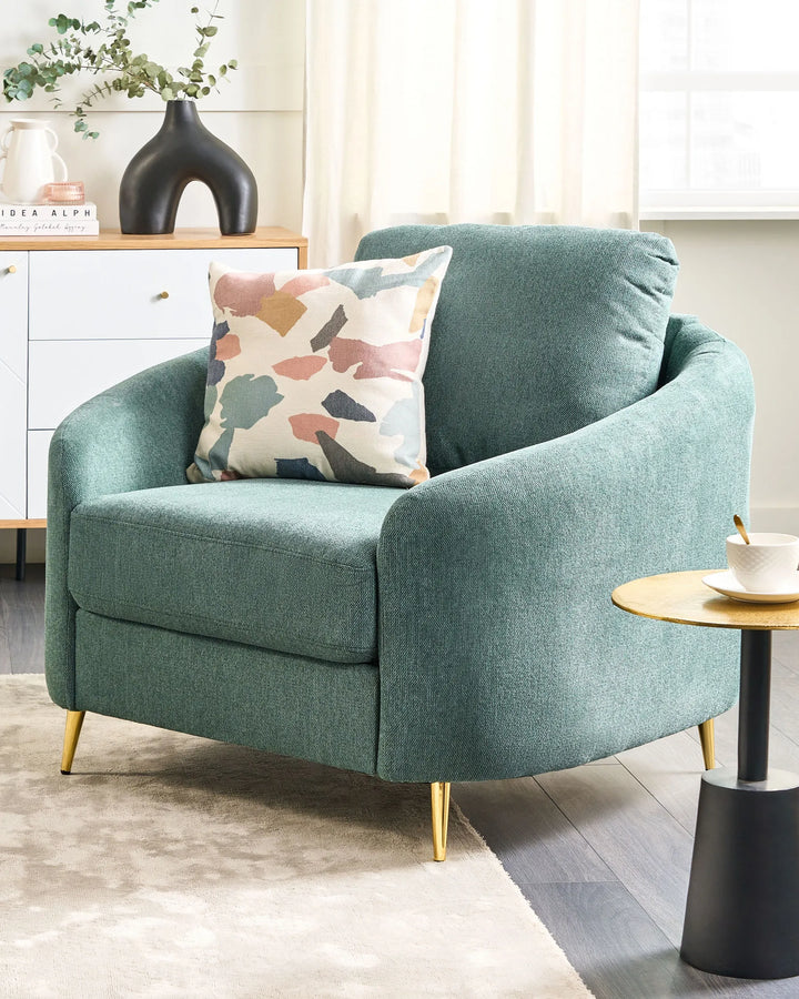 Green armchair with a colorful pillow in a living room setting