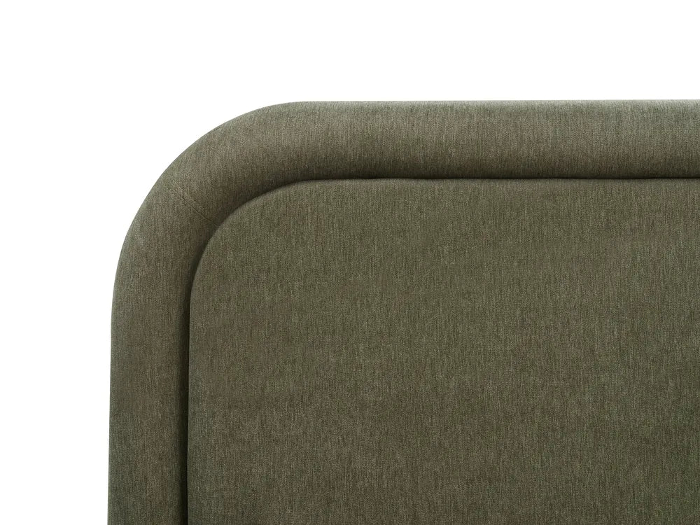 Close-up of a green upholstered chair corner on a white background