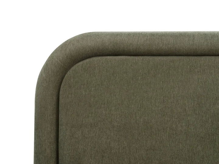 Close-up of a green upholstered chair corner on a white background