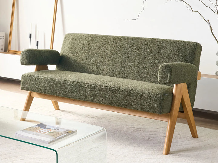 Green sofa with wooden legs in a room setting