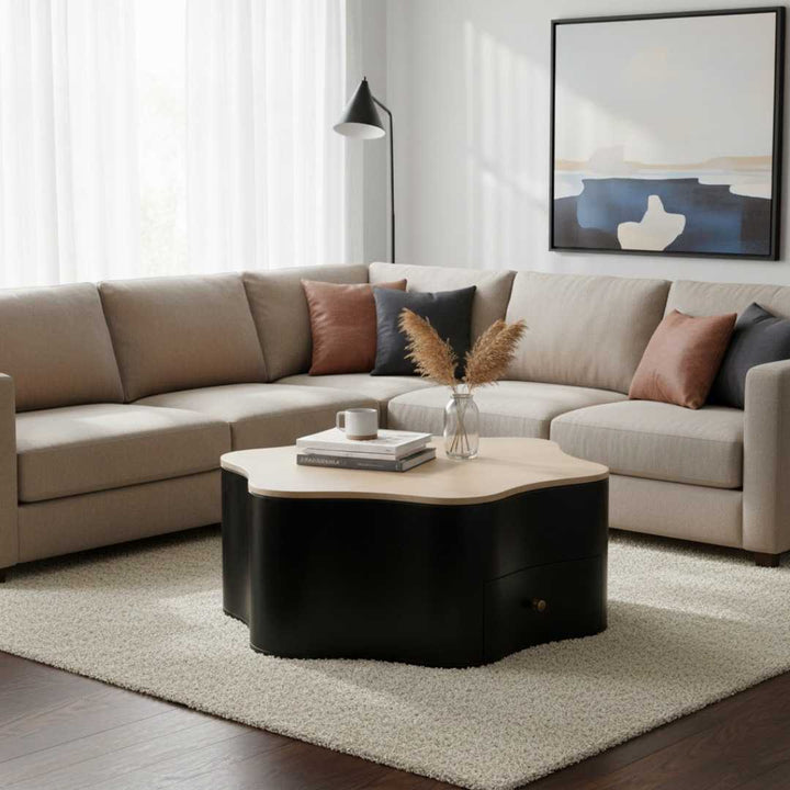 Modern living room with a beige sectional sofa, round coffee table, and abstract art on the wall.