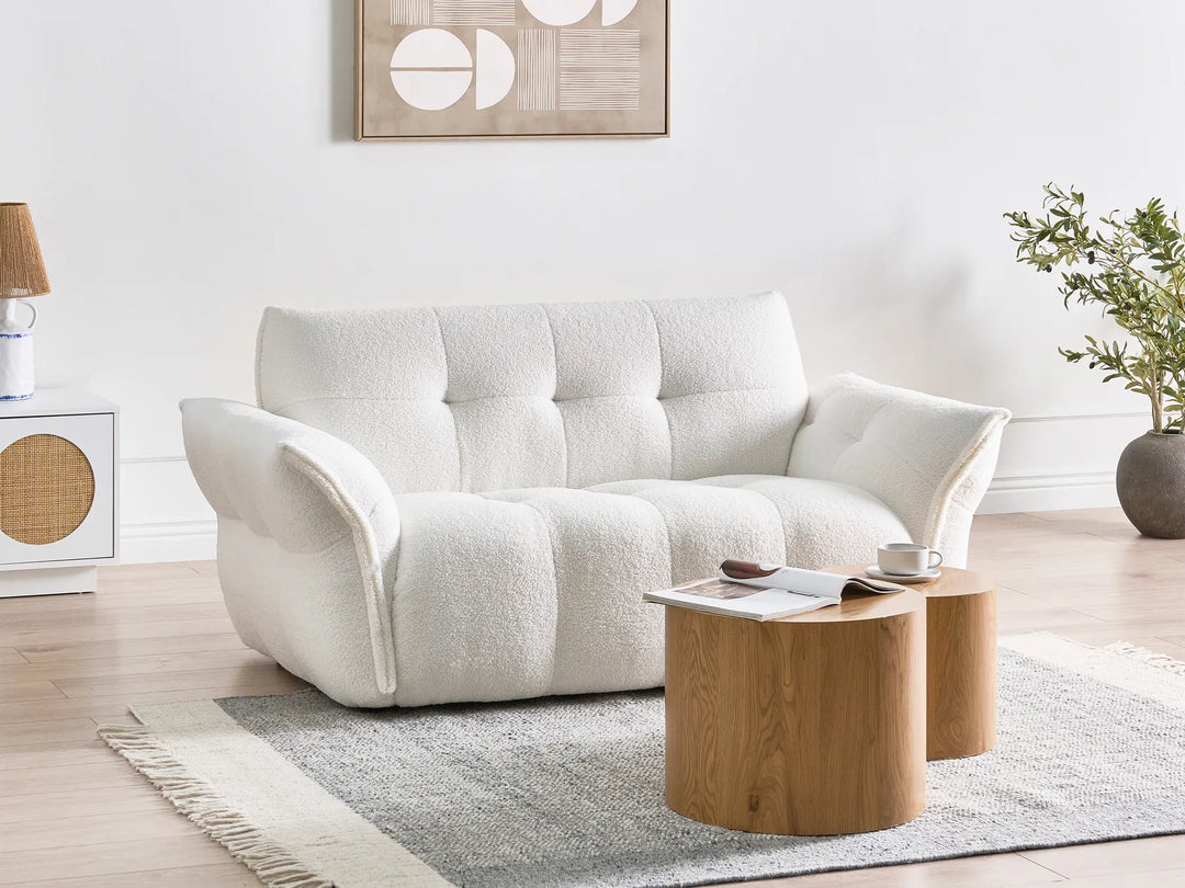 White sofa in a living room with a wooden coffee table and decorative items.