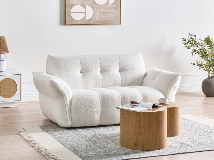 White sofa in a living room with a wooden coffee table and decorative items.