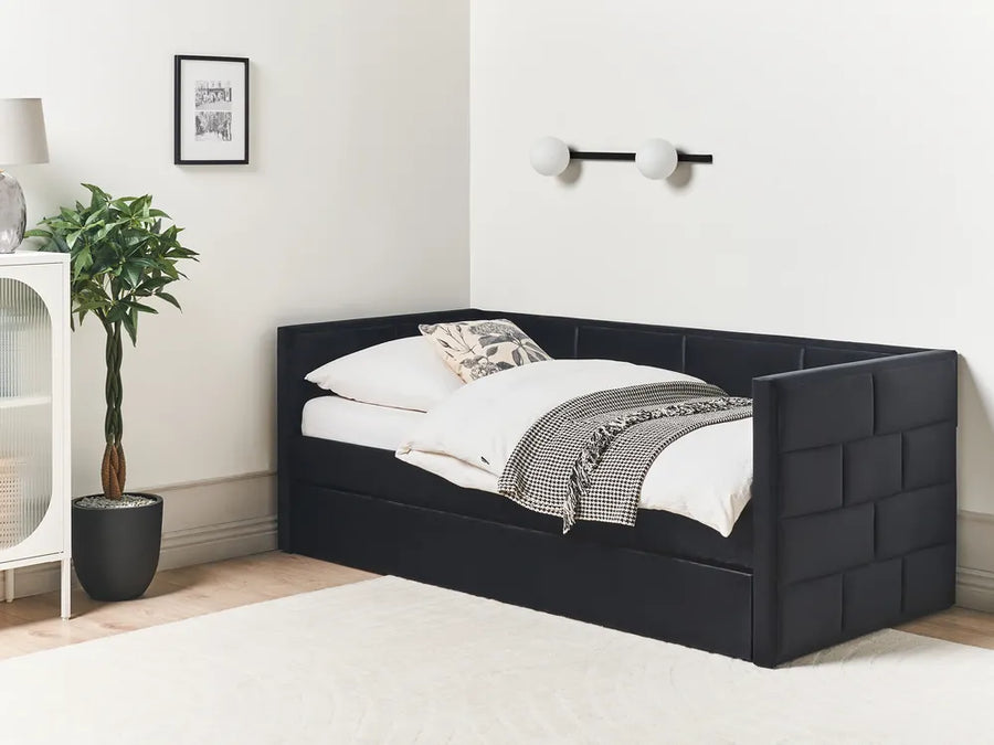 Black upholstered bed with white bedding in a room setting.