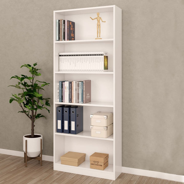 White bookshelf with books, boxes, and a plant against a gray wall.