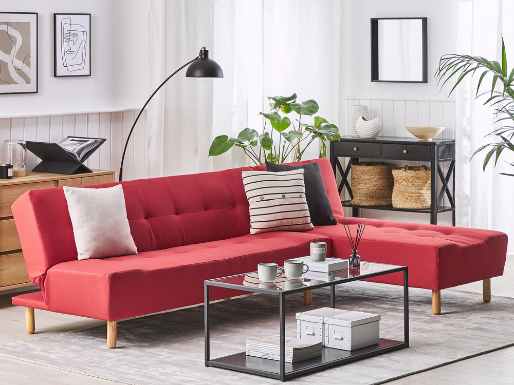 Red sectional sofa in a living room with a coffee table and decor items.