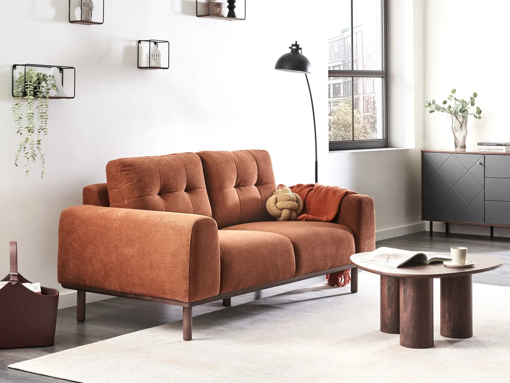 Brown sofa in a modern living room with a coffee table and decorative items.