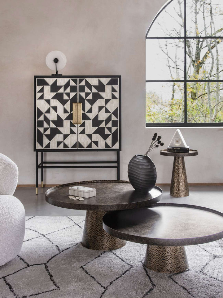 Modern interior with geometric-patterned wall art, round tables, and decorative items.