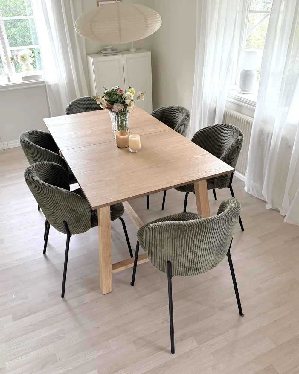 Dining room with a wooden table and gray chairs in a bright room.
