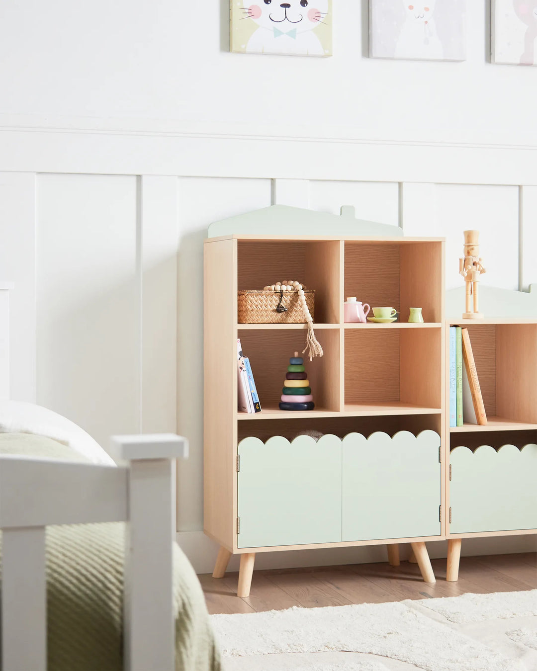 Wooden shelf with light green doors in a room with white walls and a bed.