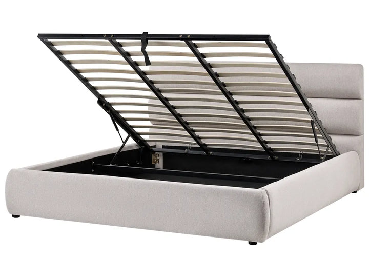 White upholstered bed with a black metal frame on a white background
