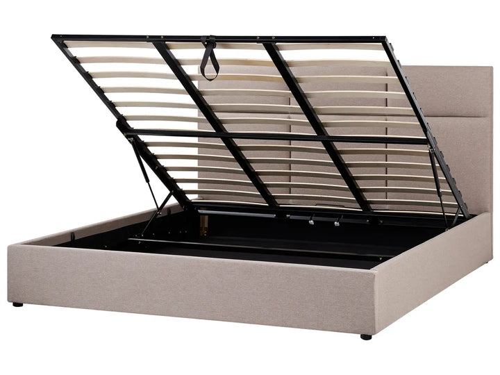 Beige upholstered bed frame with black metal headboard on a white background