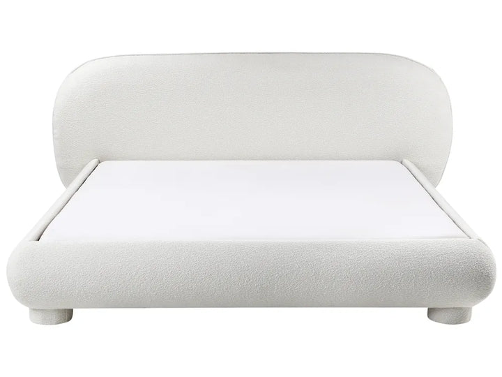 White upholstered bed with rounded design on a white background