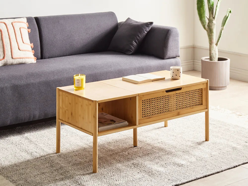 Wooden coffee table in a living room with a gray sofa and decorative items.