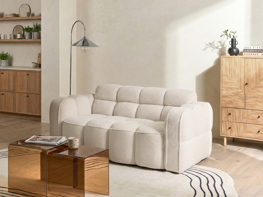 Beige sofa in a living room with wooden coffee table and cabinet.