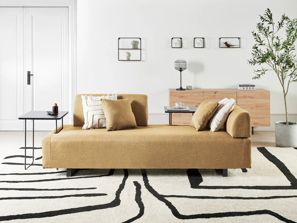 Modern living room with a beige sofa, coffee table, and decorative elements.