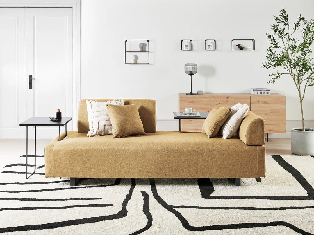 Modern living room with a beige sofa, coffee table, and decorative elements.