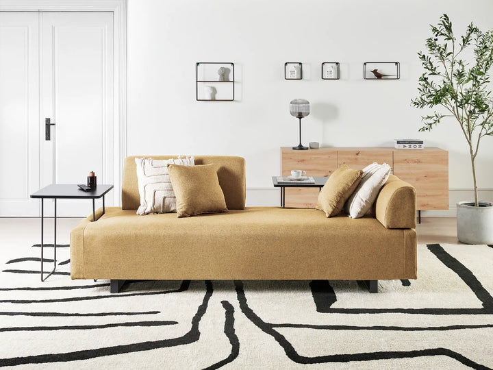 Modern living room with a beige sofa, coffee table, and decorative elements.