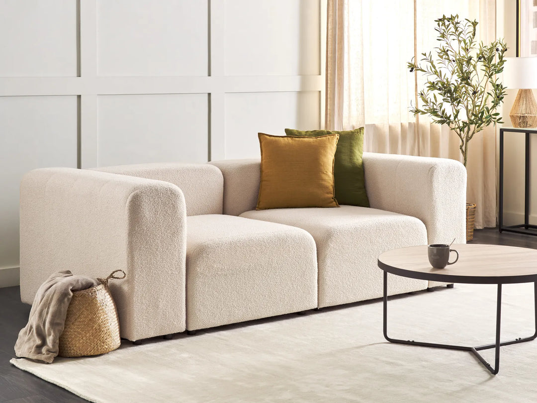 Beige sofa with green and brown cushions in a modern living room.
