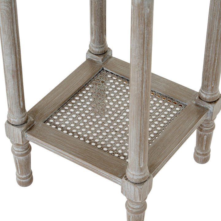 Wooden side table with caned seat on a white background