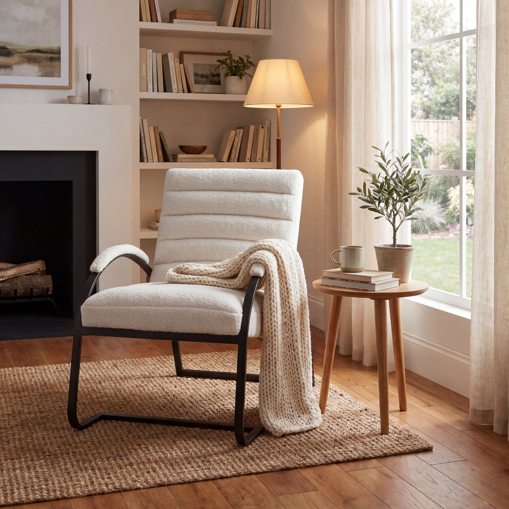 Cozy living room with a white armchair, wooden side table, and fireplace.
