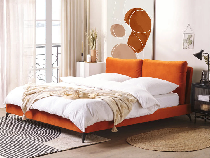 Orange bed with white bedding in a modern bedroom setting