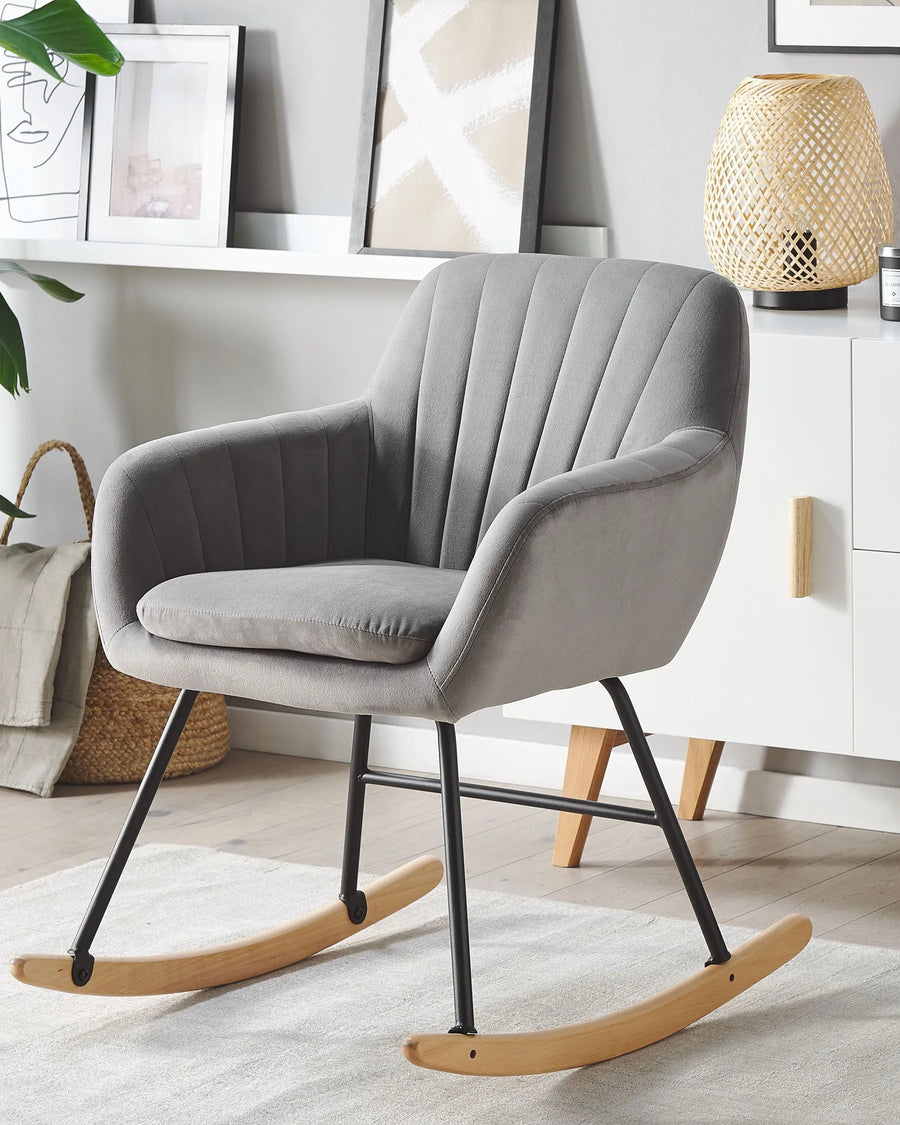 Gray rocking chair in a room with a lamp and decor