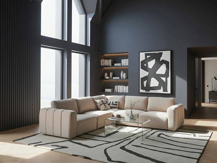 Modern living room with a beige sectional sofa, abstract art, and large windows.