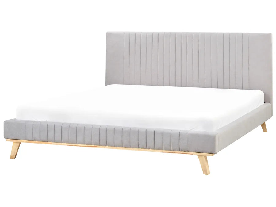 Bed with gray upholstered headboard and white mattress on a white background