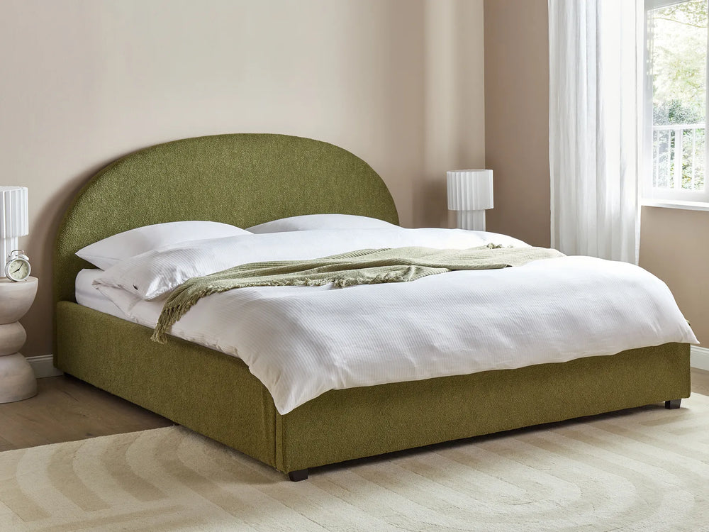 Green upholstered bed with white bedding in a bedroom setting