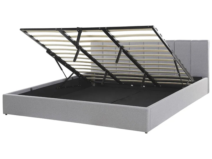 Gray upholstered bed frame with a metal headboard on a white background