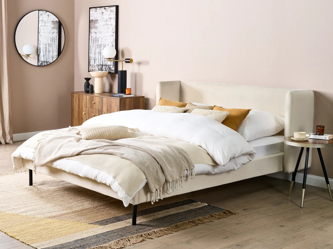 Neatly made bed in a bedroom with wooden nightstands and decorative items.