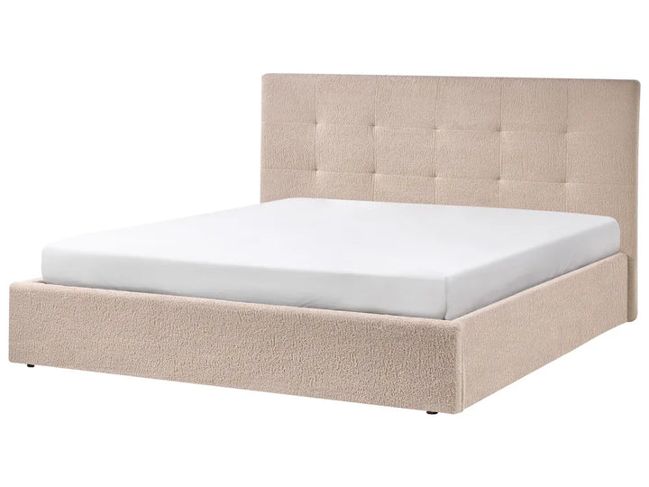 Beige upholstered bed with white mattress on a white background