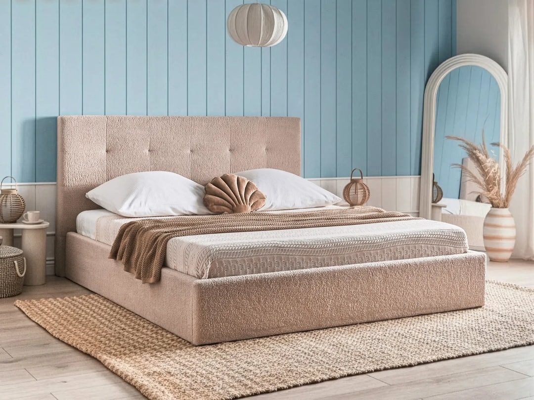 Beige upholstered bed in a bedroom with blue walls and decorative elements.