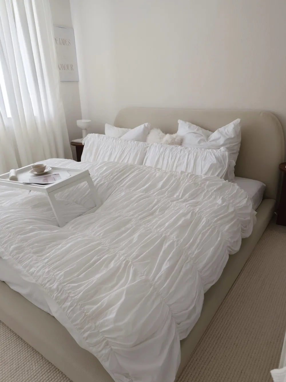 Neatly made bed with white bedding in a bedroom setting.