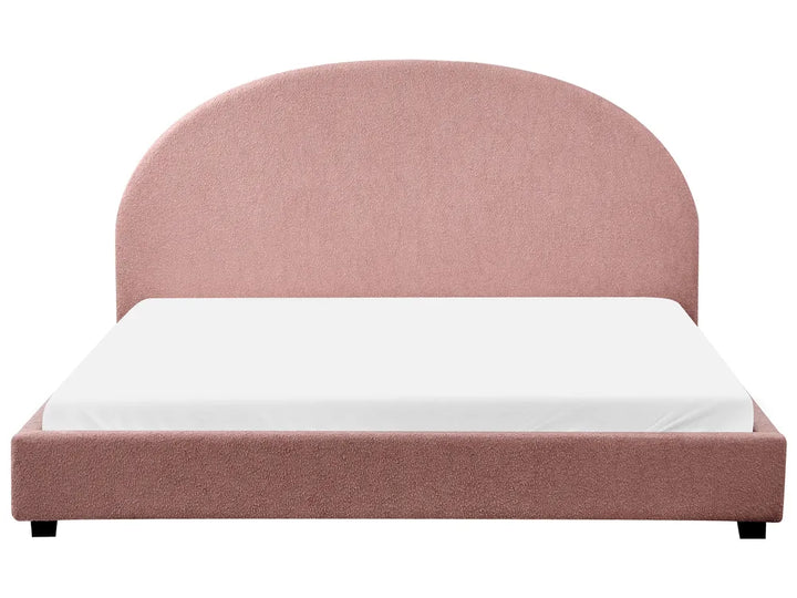 Pink upholstered bed with white mattress on a white background