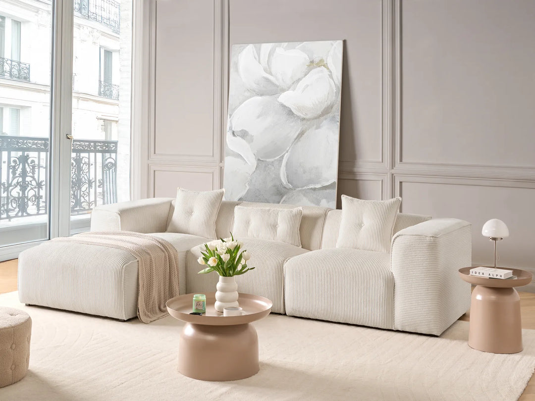 Modern living room with a white sofa, coffee table, and decorative elements.