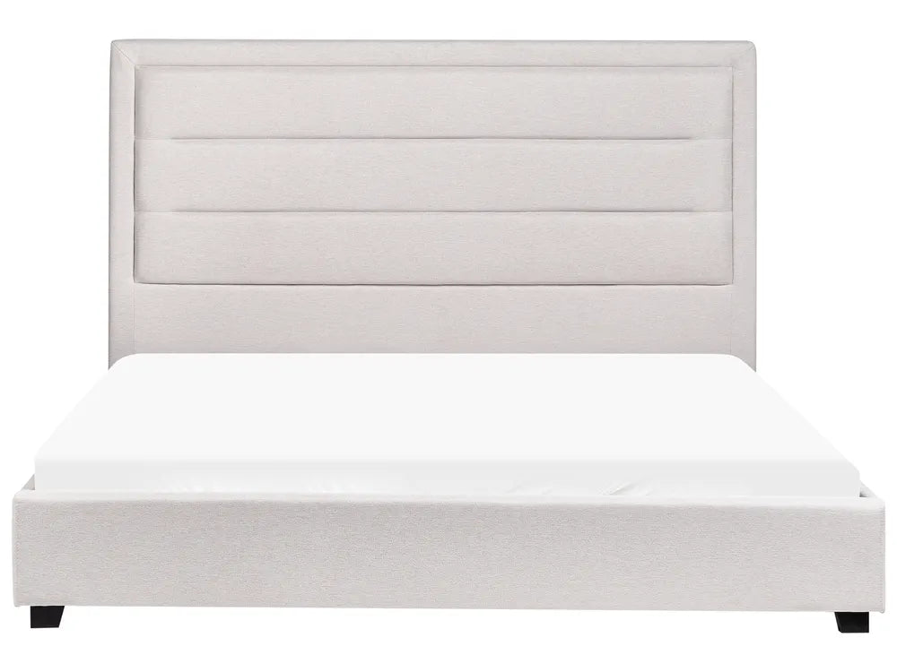 White upholstered bed with a matching headboard on a white background